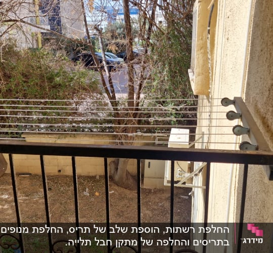 מרפסת עם חבלי כביסה ועצים ברקע
